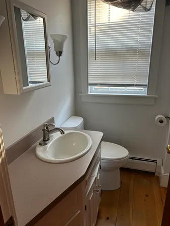 a bathroom with a sink a toilet and mirror