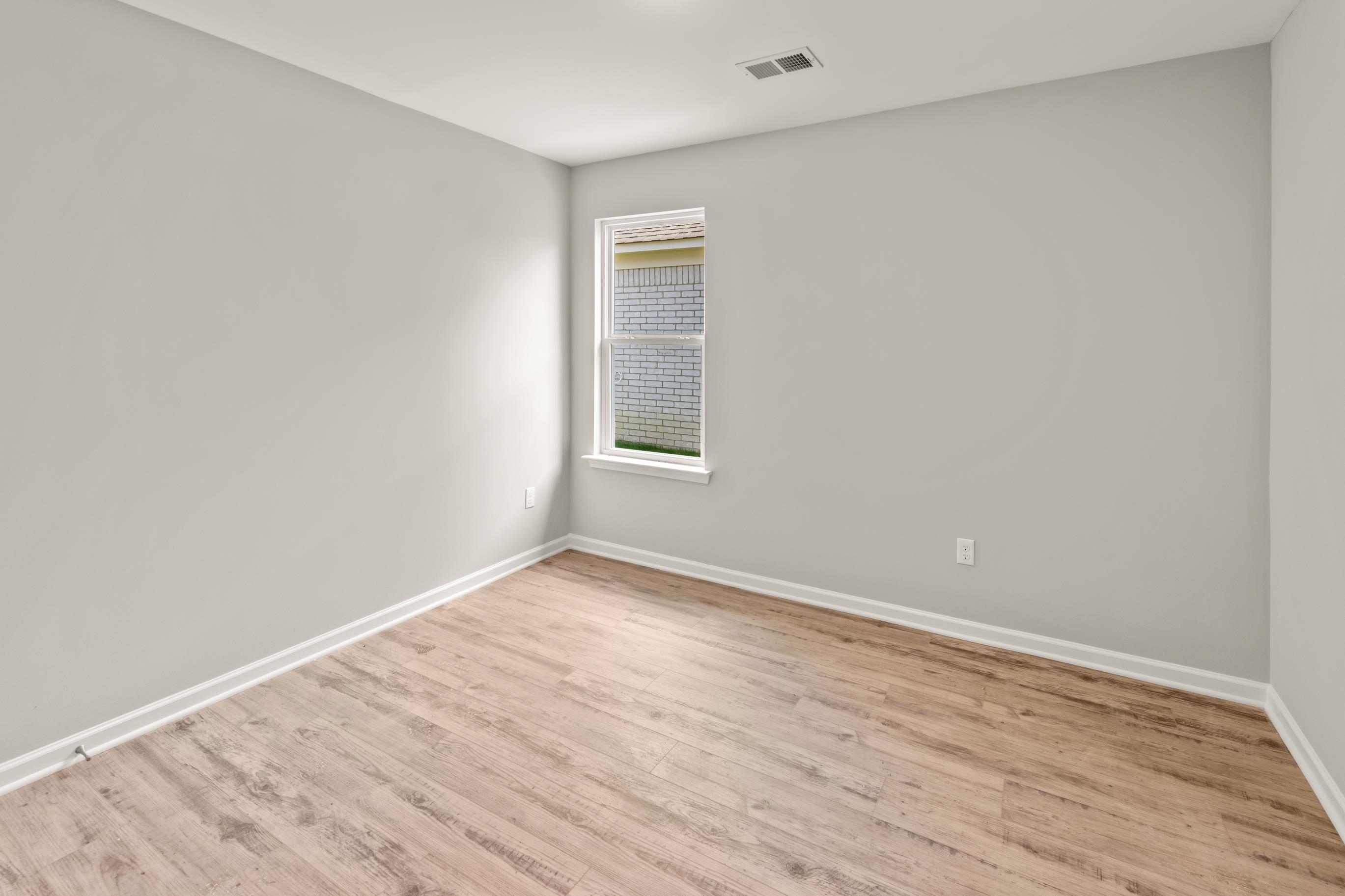 5279 Zodiac Road Memphis, TN 38118 - Photo 13 of 22 a view of an empty room with wooden floor and a window