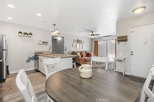 a large white kitchen with a white countertops a dining table and chairs