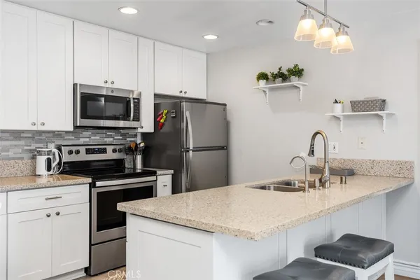 a kitchen with a sink a microwave a stove and refrigerator