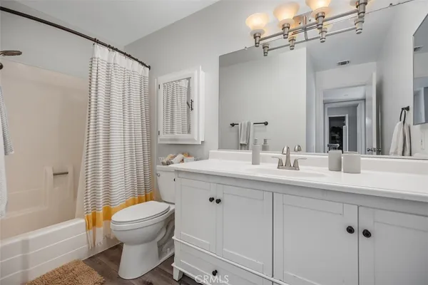 a bathroom with a toilet sink a mirror a bathtub and shower