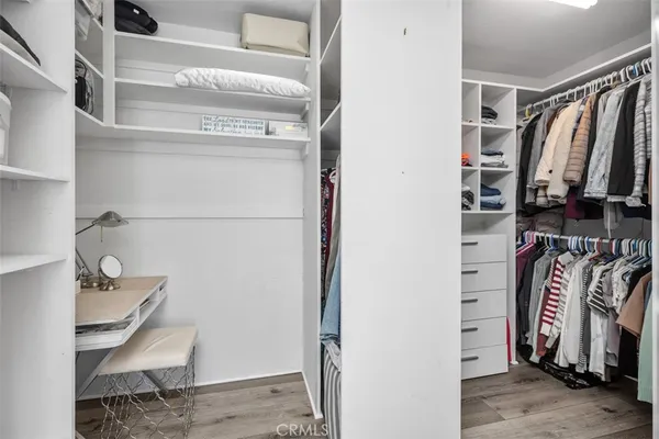 a view of walk in closet with clothes and shoes