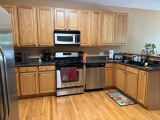 426 Vaughn Circle Aurora, IL 60502 - Photo 3 of 19 a kitchen with stainless steel appliances granite countertop a stove a sink and a microwave