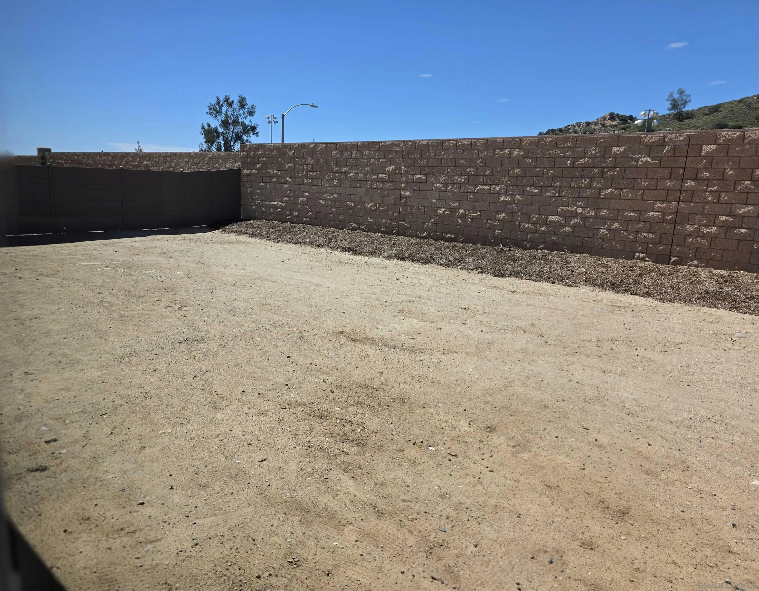3501 Butler Place Escondido, CA 92027 - Photo 14 of 15 68 W by 37.5 deep back yard. High stone wall for privacy and fencing is metal adding to fire safety and longevity.