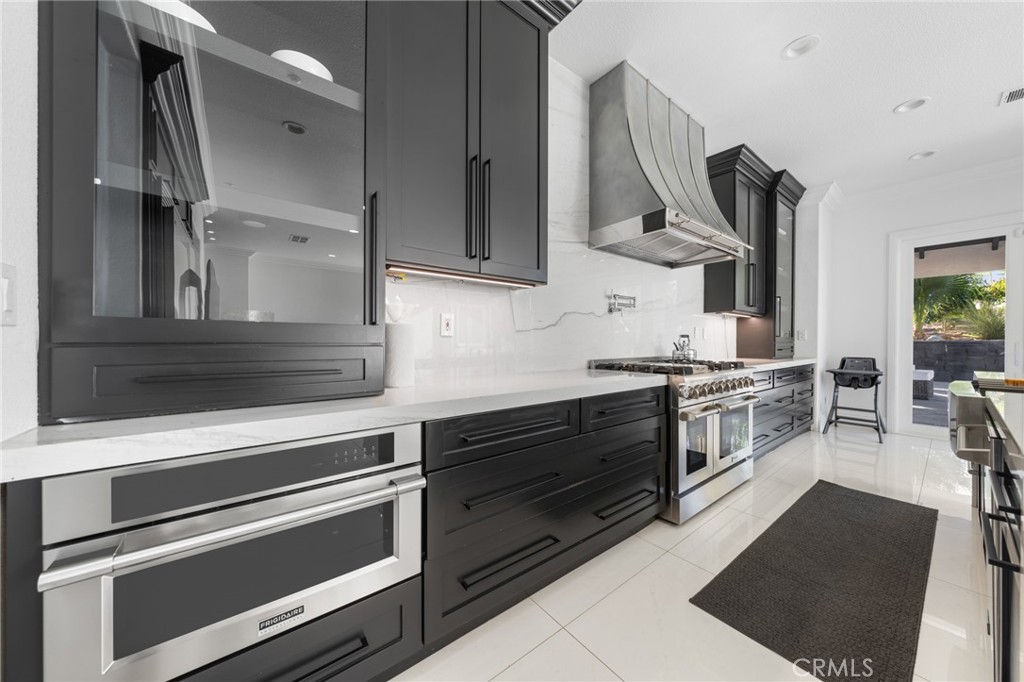 6069 Cannich Road Riverside, CA 92507 - Photo 32 of 75 a kitchen with stainless steel appliances kitchen island wooden cabinets and a stove
