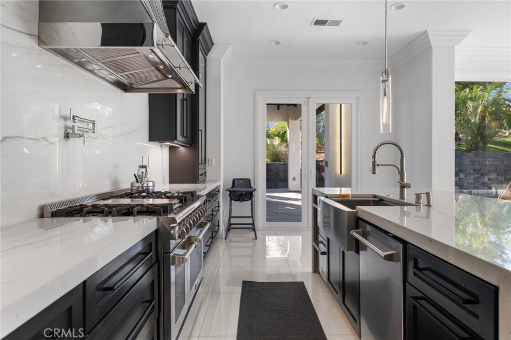 6069 Cannich Road Riverside, CA 92507 - Photo 33 of 75 a kitchen with stainless steel appliances granite countertop a sink stove and refrigerator