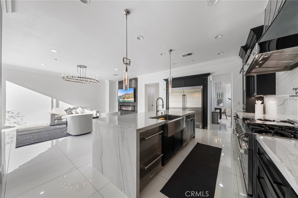 6069 Cannich Road Riverside, CA 92507 - Photo 34 of 75 a large kitchen with a large counter top stainless steel appliances and cabinets