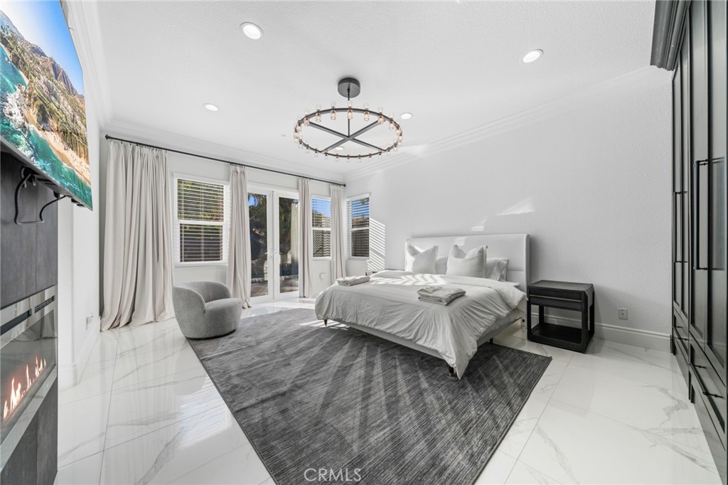 6069 Cannich Road Riverside, CA 92507 - Photo 46 of 75 a bedroom with a large bed and a chandelier
