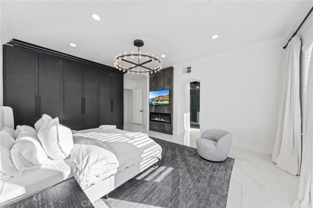 6069 Cannich Road Riverside, CA 92507 - Photo 47 of 75 a spacious bedroom with a bed and a chandelier