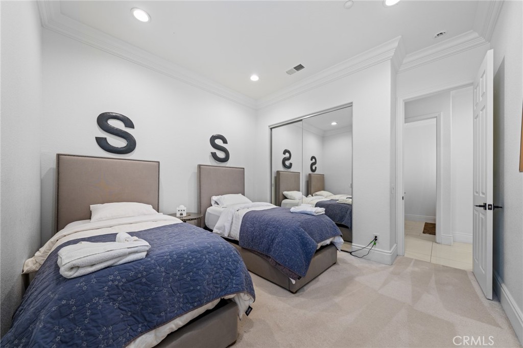 6069 Cannich Road Riverside, CA 92507 - Photo 56 of 75 a bedroom with two beds and a chandelier