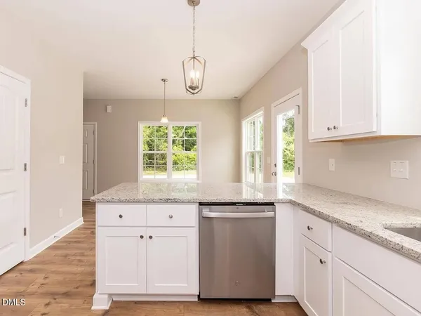 a kitchen with granite countertop white cabinets and a window