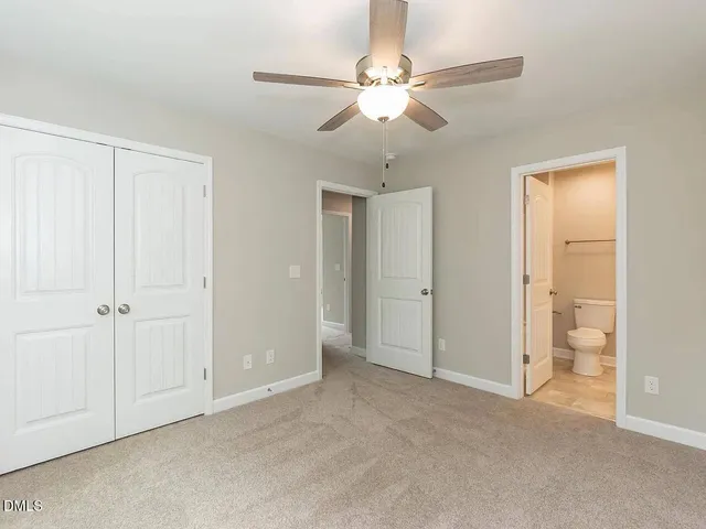 an empty room with fan closet and fan