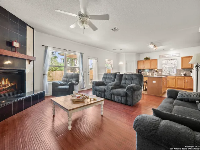 a living room with furniture kitchen view and a fireplace