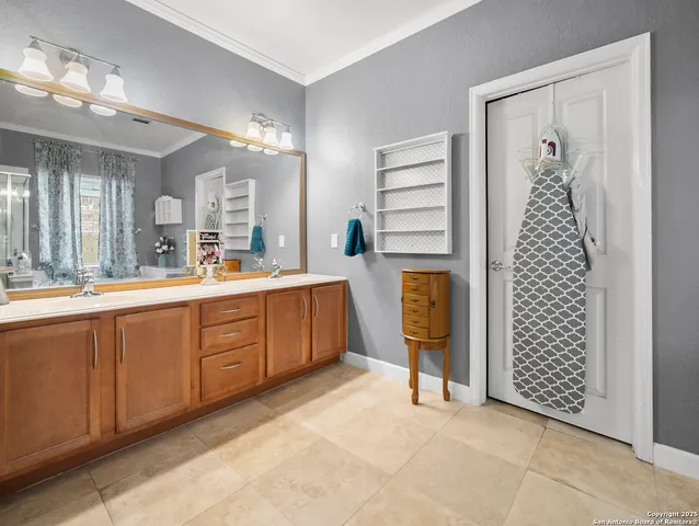 a spacious bathroom with a double vanity sink a large mirror and a shower