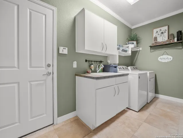 a utility room with cabinets washer and dryer