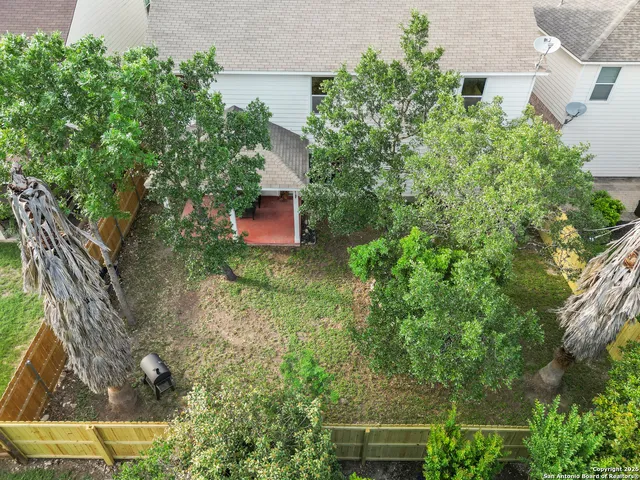 an aerial view of residential house with outdoor space and trees all around