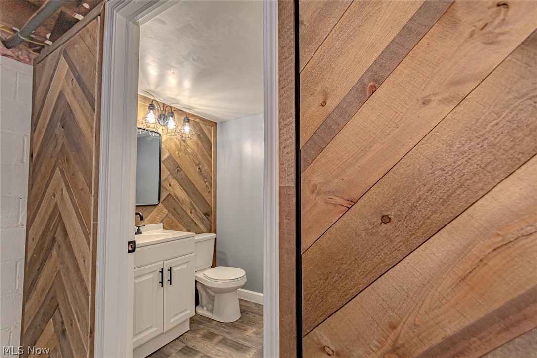 4157 Verona Road Cleveland, OH 44121 - Photo 21 of 26 Bathroom with vanity, wood walls, and light wood-style flooring