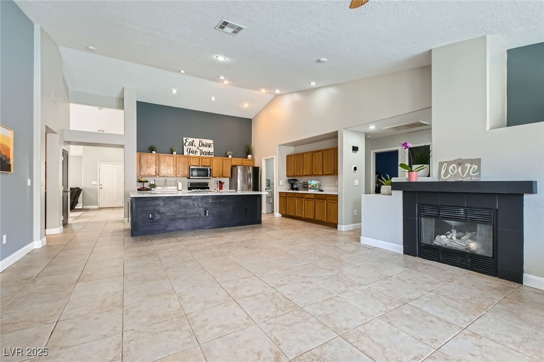 8920 Rusty Rifle Avenue Las Vegas, NV 89143 - Photo 7 of 37 Kitchen featuring high vaulted ceiling, stainless steel appliances.