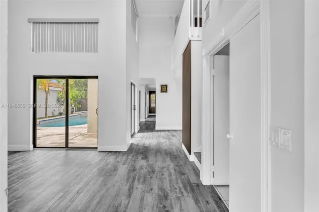 a living room with furniture kitchen view and a window