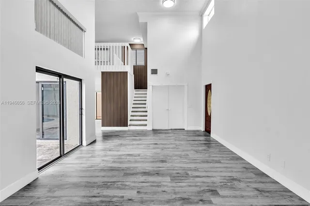 a view of a hallway with wooden floor and entryway