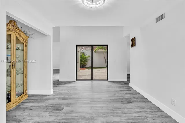 a kitchen with kitchen island a sink wooden floor and a refrigerator