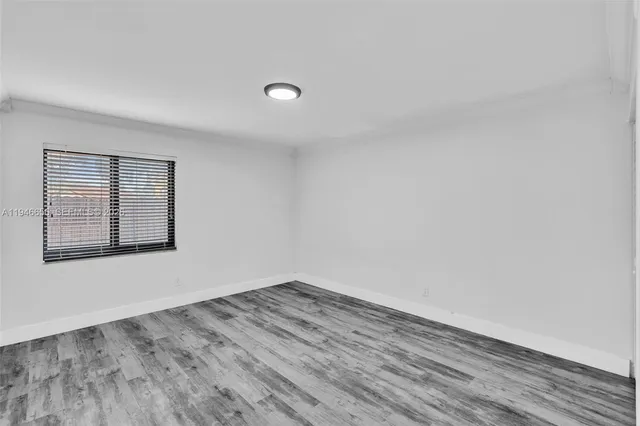 a view of room with window and wooden floor