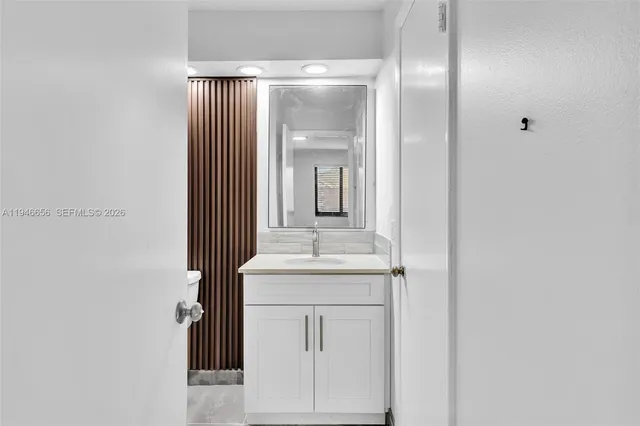 a bathroom with a granite countertop sink a mirror and a bathtub