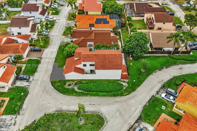 an aerial view of residential houses with outdoor space and street view