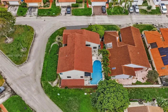 a view of a house with a small yard and a large tree