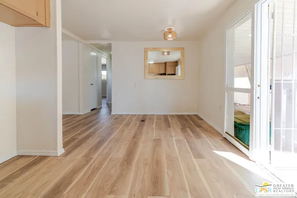 a view of a room with wooden floor and a window