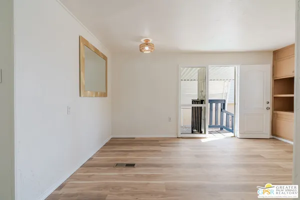 a view of a kitchen with wooden floor and a ceiling fan
