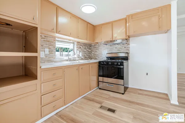 a kitchen with stainless steel appliances granite countertop a stove a sink and a refrigerator