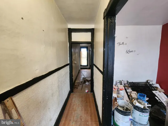 a view of a hallway with wooden floor and a bathroom
