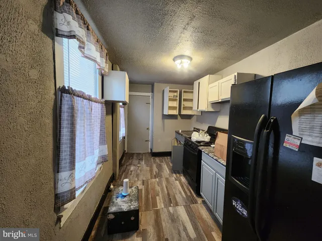 a view of a refrigerator in kitchen and wooden floor