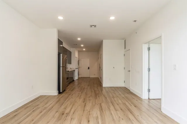 a view of a hallway with wooden floor