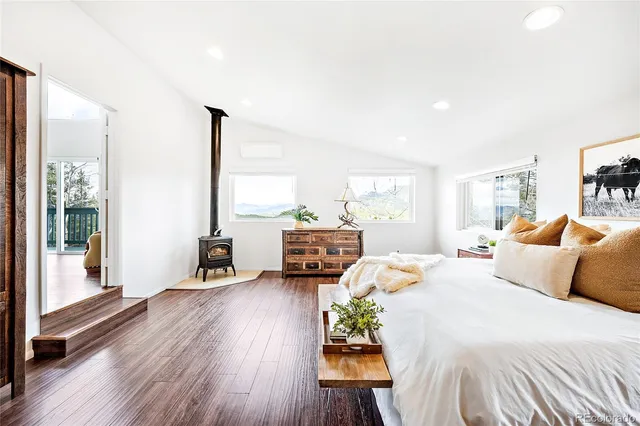 a bedroom with a bed and large windows