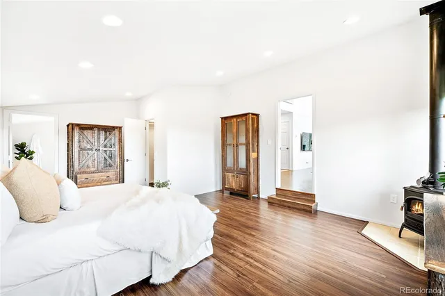 a spacious bedroom with a bed and wooden floor