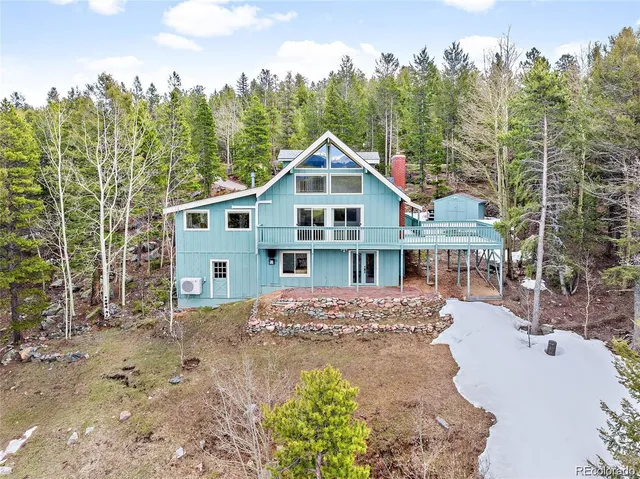 a view of a house with a yard and trees