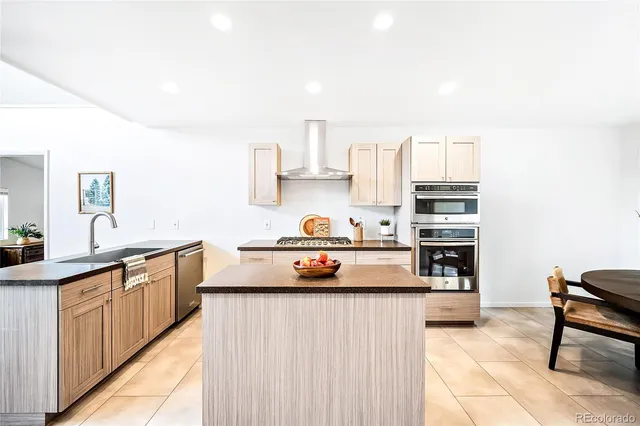 a kitchen with stainless steel appliances a stove a sink and a refrigerator