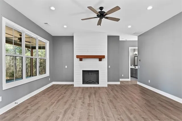 a large kitchen with stainless steel appliances a large counter top a sink a refrigerator and a window