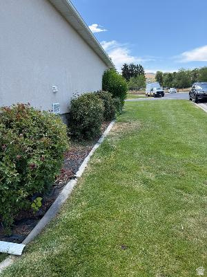 641 East Greystone Way Tooele, UT 84074 - Photo 28 of 30 Stucco exterior with a fascia and soffit, complemented by mature shrubbery and a manicured lawn
