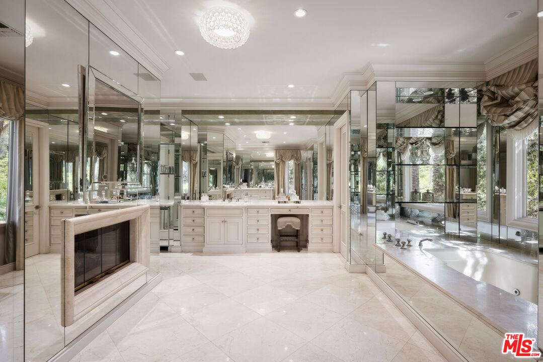 1160 Chantilly Road Los Angeles, CA 90077 - Photo 21 of 32 a large white kitchen with a sink and stainless steel appliances