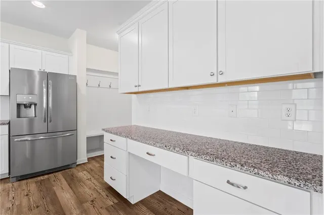a kitchen with granite countertop white cabinets and stainless steel appliances