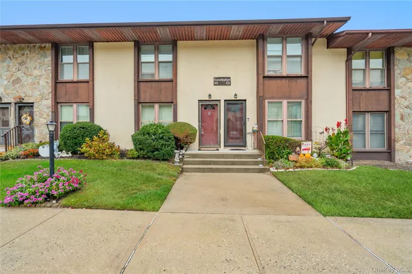 front view of a brick house with a yard