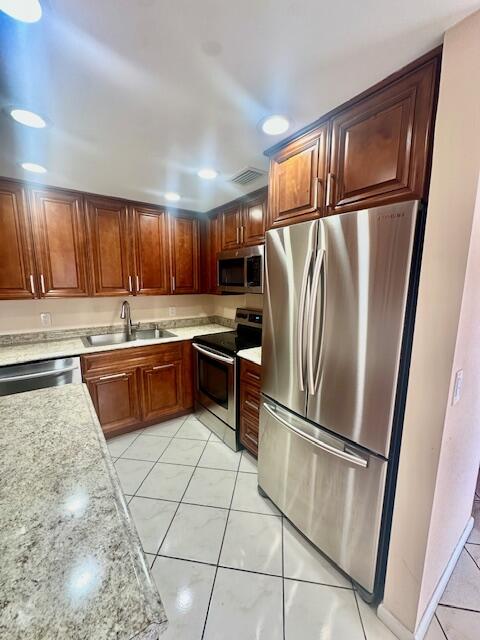 69 Dorset B Boca Raton, FL 33434 - Photo 3 of 25 a kitchen with granite countertop a refrigerator and a stove top oven