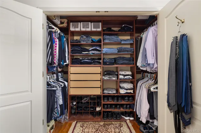 a view of walk in closet with clothes and shoes