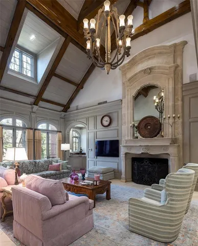 a living room with furniture a fireplace and a chandelier