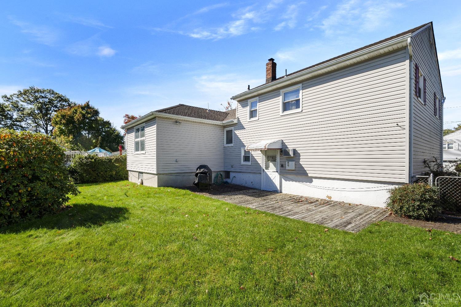 7 Garside Place Clark, NJ 07066 - Photo 3 of 34 a view of a white house with a big yard and large trees