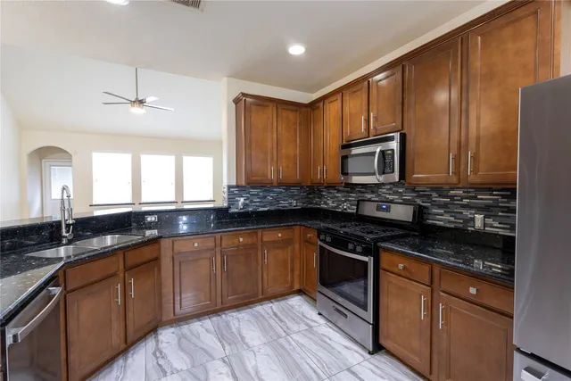 a kitchen with granite countertop stainless steel appliances and cabinets