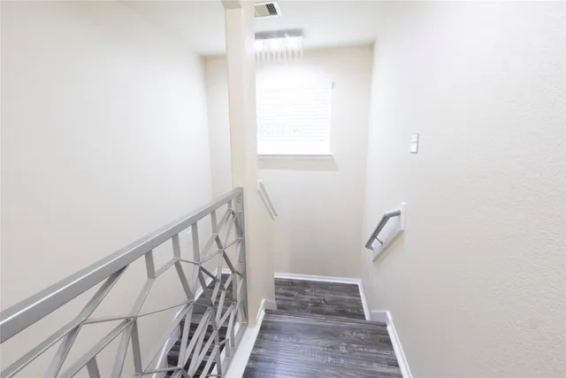 a view of a hallway with wooden floor and staircase